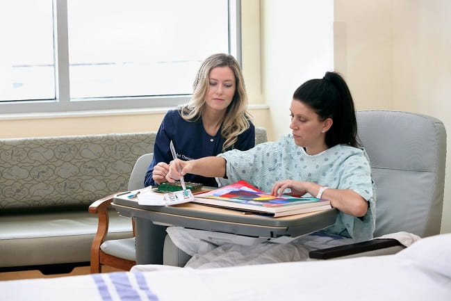 Art therapist with a patient in their room