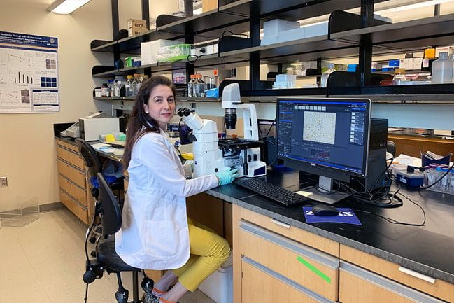 Dr. Blanco in her lab with a microscope.