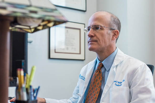 Dr. Judge in a white coat looking at his computer