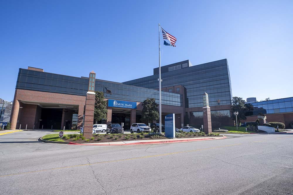 Outdoor view of a hospital with a flag out front.