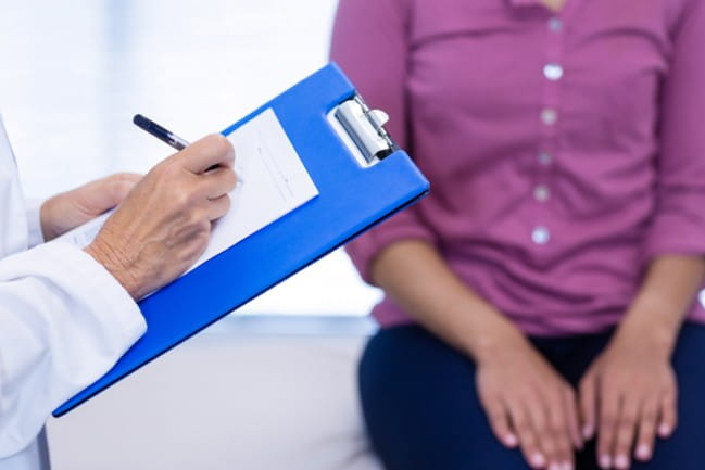 Care team member with patient filling out pre-admission form.