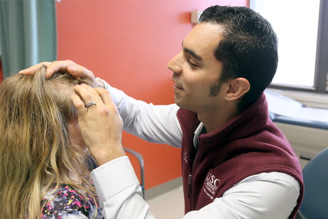 Ramin Eskandari, M.D., examines child’s head