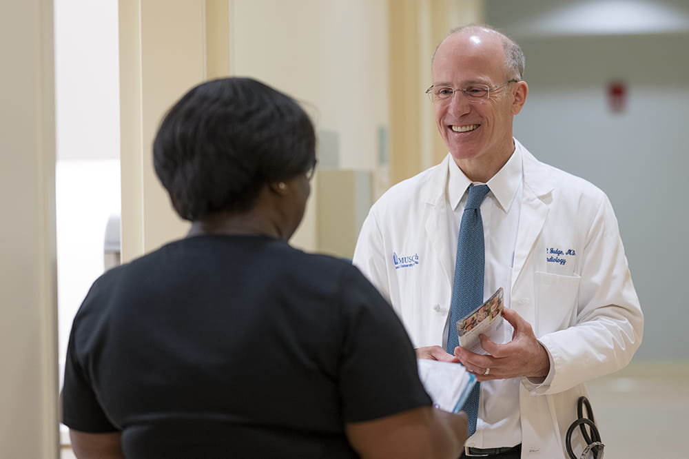 Dr. Daniel Judge speaking with a colleague