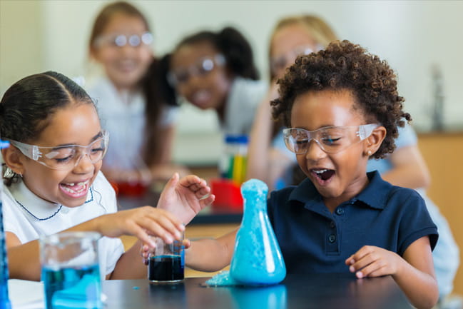 Two girls conduct a science experiment in school