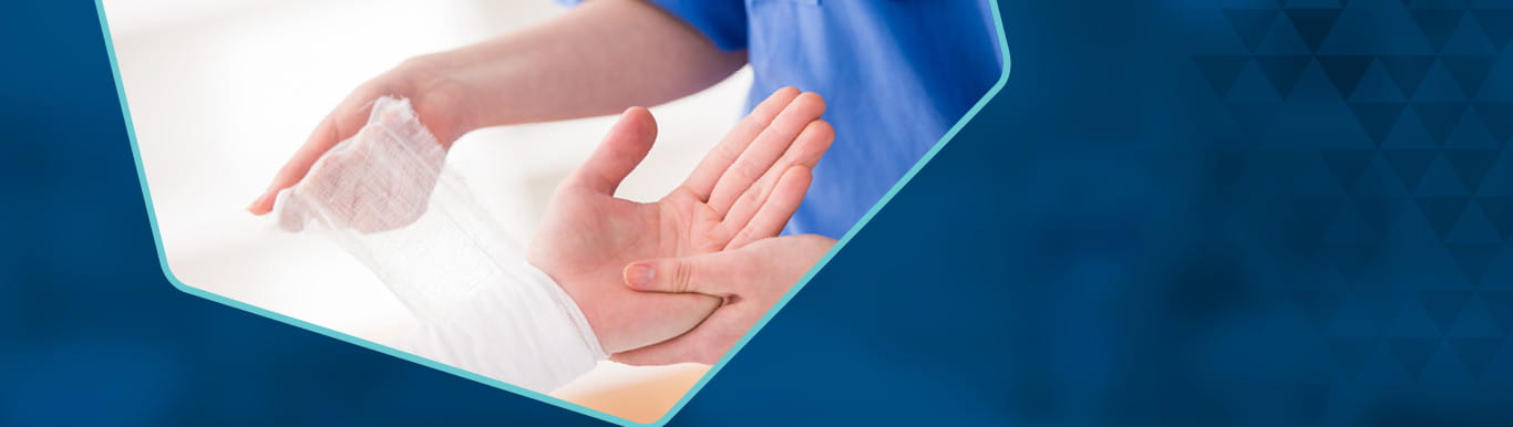 A person's wrist being bandaged by a healthcare professional.