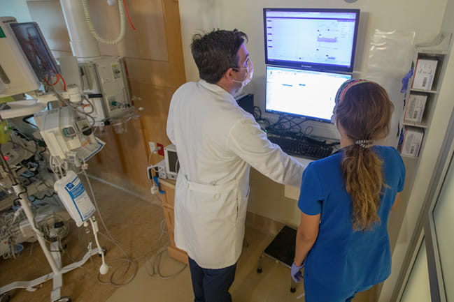  Dr. Zeigler in a white coat reviewing patient data with nurse Hannah Brown in blue scrubs. 