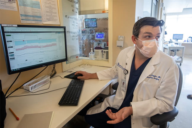 Dr. Zeigler in a white coat looking at his computer screen.